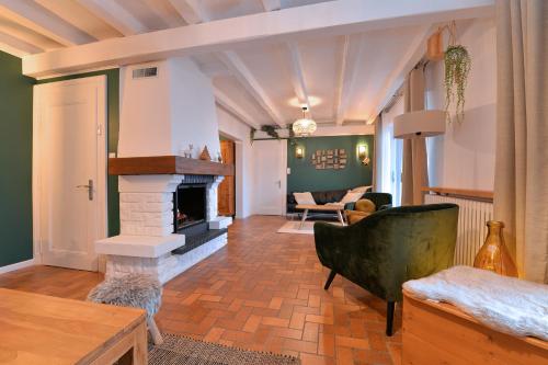 A l'Oree du Bois في لابروتشه: غرفة معيشة مع موقد وأريكة
