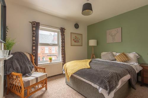 a bedroom with a bed and a chair and a window at Woodside House - 4 Bed Town House - Central Reading - Free Parking in Reading