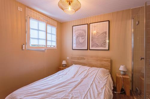 een slaapkamer met een bed en een glazen douche bij Appartement entièrement rénové proche des commerces in Biarritz