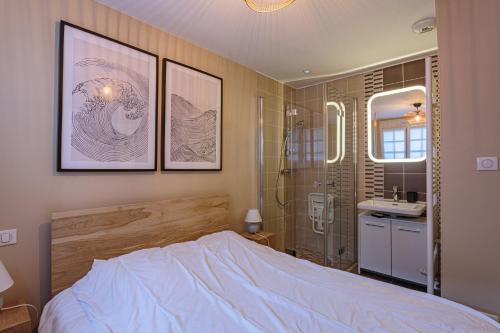 een slaapkamer met een bed, een douche en een wastafel bij Appartement entièrement rénové proche des commerces in Biarritz