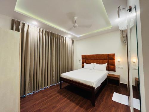 a bedroom with a bed and a window with curtains at Ticlo Resorts in Calangute