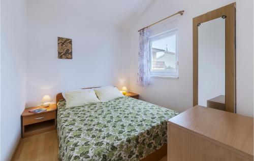 a small bedroom with a bed and a window at Nice Apartment In Pula With Kitchen in Medulin