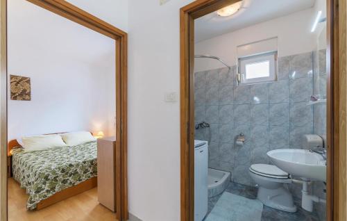 a bathroom with a toilet and a sink and a bed at Nice Apartment In Pula With Kitchen in Medulin
