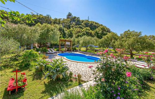 a garden with a swimming pool and some flowers at Beautiful Apartment In Mundanije With Kitchen in Mundanije