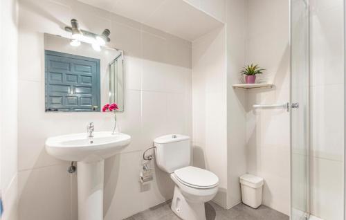 a white bathroom with a toilet and a sink at Urb Panorama in Taramay