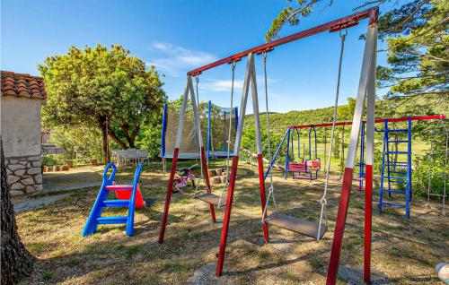 a playground with colorful swings in a yard at Beautiful Apartment In Mundanije With Kitchen in Mundanije