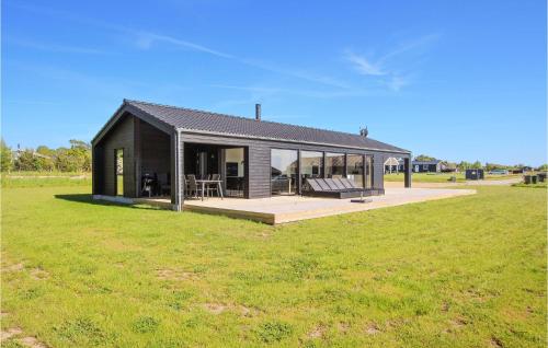 a black house with a large green field at Cozy Home In Samsø With Sauna in Nordby