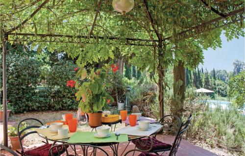 patio z dwoma stołami i krzesłami pod pergolą w obiekcie Calistemo w mieście Turignano