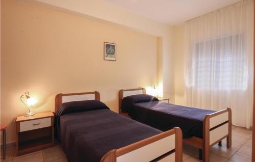 アックエドルチにあるAlloggio Danielaのベッド2台と窓が備わるホテルルームです。