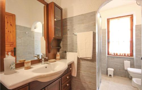 bagno con lavandino, servizi igienici e specchio di Villino Mito a San Teodoro