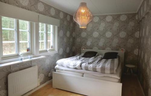 a bedroom with a bed and a window and a chandelier at Beautiful Home In Gislaved in Gislaved