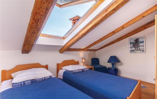 2 łóżka w pokoju z drewnianymi belkami stropowymi w obiekcie Nice Apartment In Fazana With 2 Bedrooms w Fažanie