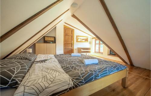 a attic bedroom with a bed with blue pillows on it at Gorgeous Home In Radovanci With Jacuzzi 
