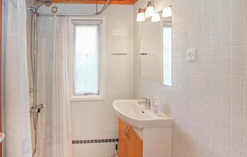 ein weißes Badezimmer mit einem Waschbecken und einem Spiegel in der Unterkunft Nice Home In Sams With Kitchen in Kolby Kås