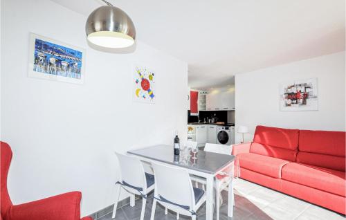 salon z czerwoną kanapą i stołem w obiekcie Beach Front Apartment w mieście Saint-Cyprien-Plage