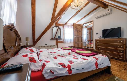 Un dormitorio con una cama con flores rojas. en Cozy Home In Klanjec With House A Panoramic View, en Klanjec
