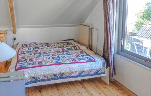 um pequeno quarto com uma cama e uma janela em Oostrumerbocht em Oostrum