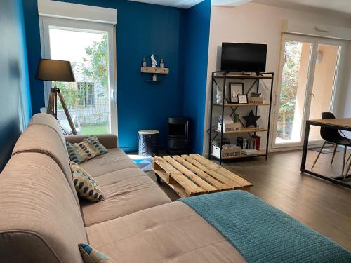 a living room with a couch and a tv at Le Parc in Bergerac