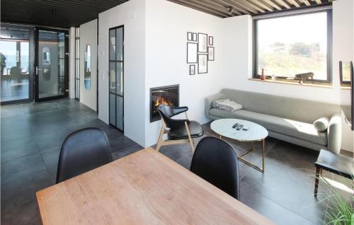 a living room with a table and a fireplace at Awesome Home In Samsø With Sauna in Onsbjerg