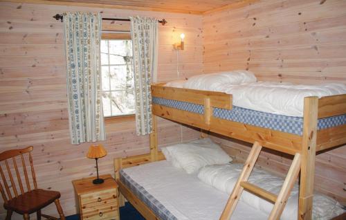 two bunk beds in a log cabin with a window at Nice Home In Lindesnes With House Sea View in Svenevik