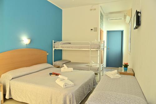 1 dormitorio con 2 camas y toallas. en Hotel ITALY, en Misano Adriatico