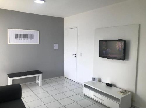 a living room with a tv on a white wall at Apto em condomínio , portaria 24h, com área de lazer, ideal para famílias in Imperatriz