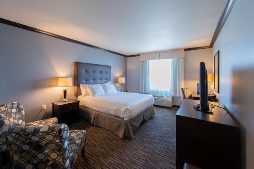 una camera d'albergo con letto e TV di Prestige Treasure Cove Resort, WorldHotels Elite a Prince George