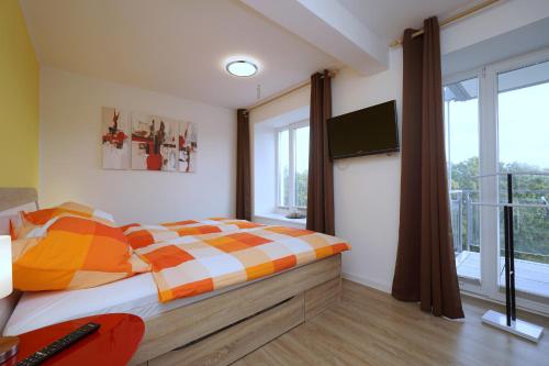 - une chambre avec un lit et une télévision dans l'établissement APRICUM - Mein Sonnenlicht - Haus Granitz, à Binz