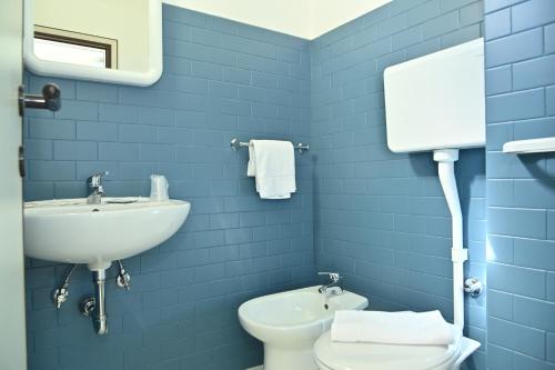 Baño azul con lavabo y aseo en Hotel ITALY, en Misano Adriatico