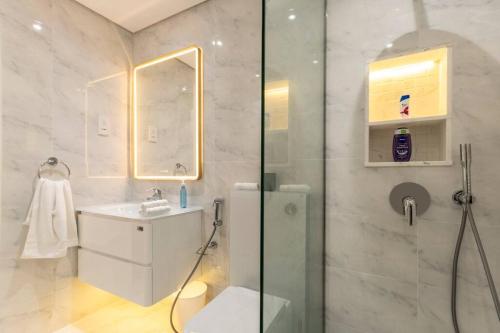 a bathroom with a shower and a toilet and a sink at Bright & Relaxing 1BR Apartment in Dubai