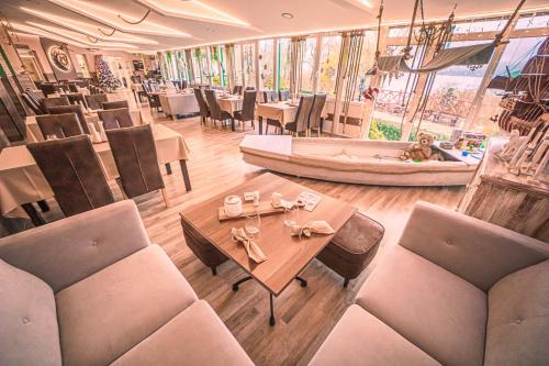 a restaurant with a table and chairs and a person laying down at Mártoni Resort & Restaurant in Szigetszentmárton