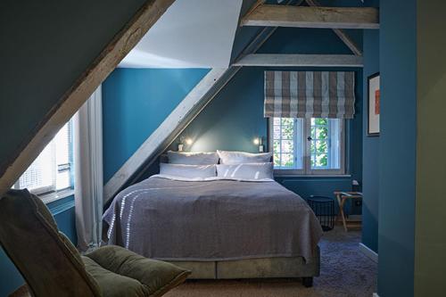 1 dormitorio con 1 cama en una habitación azul en Landhaus Jenischpark en Hamburgo
