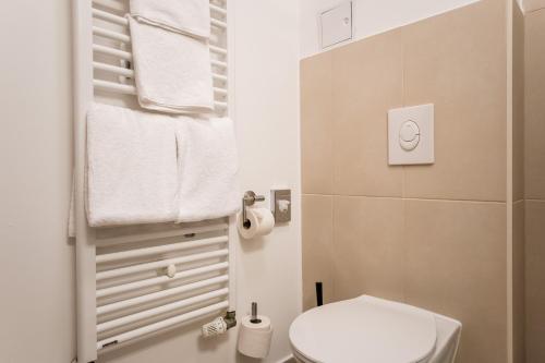 uma pequena casa de banho com um WC branco e toalhas em Homaris Boxi Studios em Berlim