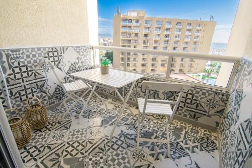 a balcony with a table and chairs on a tile floor at Apartment Puerto Marina - First Line Beach - Benalmadena - Málaga in Benalmádena