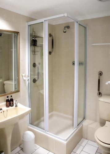 a white bathroom with a shower and a toilet at Bayview 305A in Hermanus