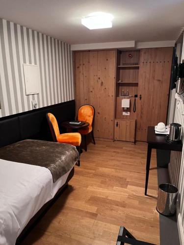 a hotel room with a bed and a table and chairs at Logis Hôtel Ettenheim in Strasbourg
