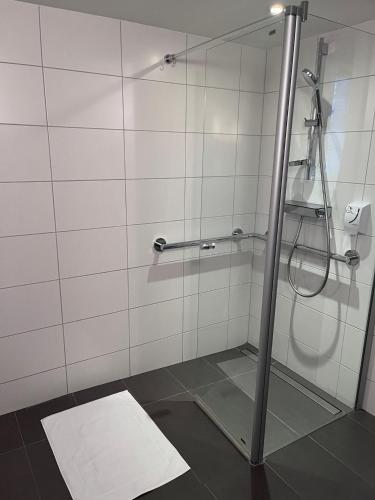 a shower with a glass door in a bathroom at Logis Hôtel Ettenheim in Strasbourg