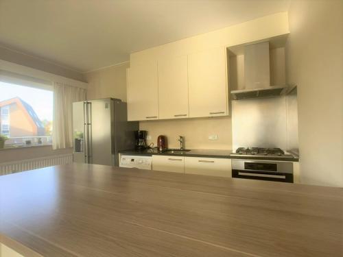 a kitchen with white cabinets and a wooden counter top at Wijk de Brabander 61 in Cadzand