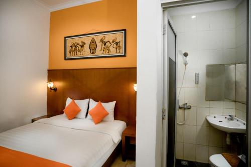 ein Hotelzimmer mit einem Bett und einem Waschbecken in der Unterkunft Hotel Poncowinatan - Tugu in Yogyakarta