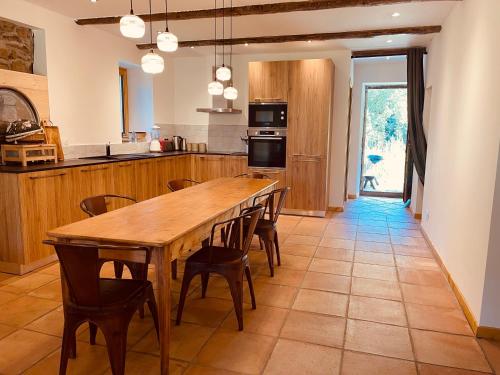 eine große Küche mit einem Holztisch und Stühlen in der Unterkunft Le Chalet de Bémont in Samoëns