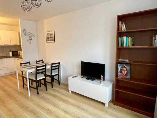 a living room with a dining room table with a television at Town Center Chmielna 116/118 in Warsaw