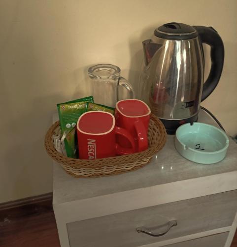 a basket on a counter with cups and a kettle at Nirvana Kuti in Kathmandu