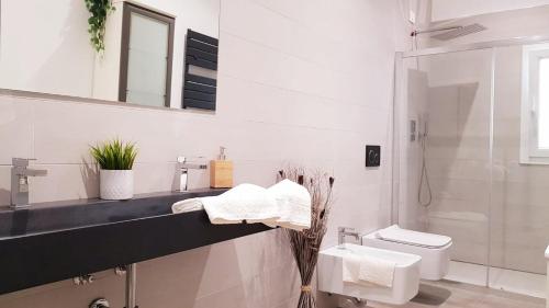 a white bathroom with a sink and a toilet at Appartamento Garden in Riccione