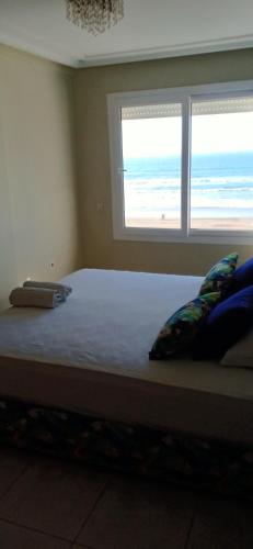 a bedroom with a bed with a view of the beach at Appartement résidence Atlantic 1 in Kenitra