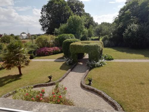 a garden with a bench in the middle of a park at Victoria Arromanches B&B in Tracy-sur-Mer
