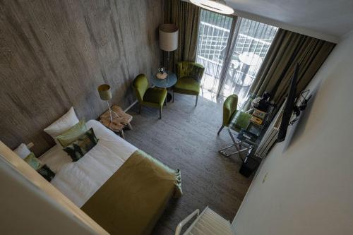 a bedroom with a bed and a table and chairs at Boutique Hotel Slenaker Vallei - Buitengewoongenieten in Slenaken