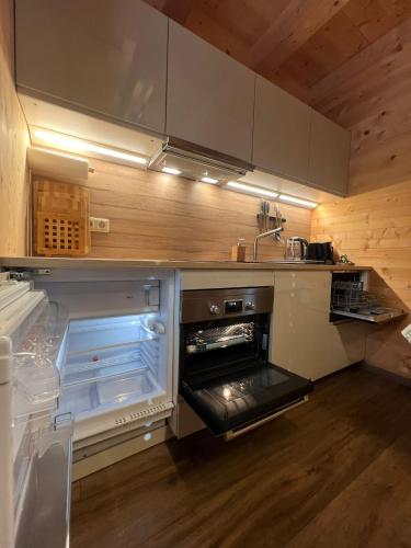 an empty kitchen with an open oven in it at Alpenburg Bergparadies Apartments in Wald am Arlberg