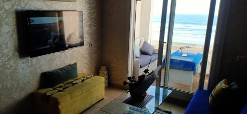 ein Wohnzimmer mit Blick auf den Strand in der Unterkunft Appartement résidence Atlantic 1 in Kenitra