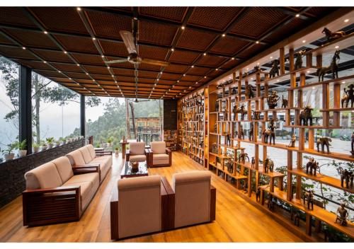 a library with couches and shelves of books at Chandys Drizzle Drops - Munnar Top Station in Munnar