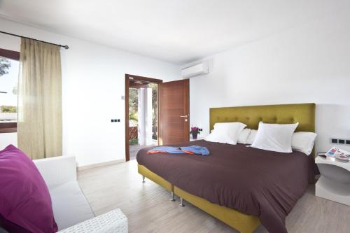 a bedroom with a large bed and a bathroom at Santerra - San Jose in Cala Bassa